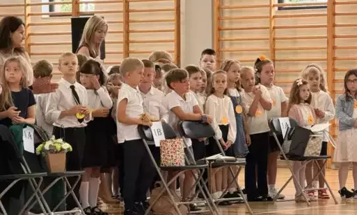 Grupa pierwszoklasistów z wychowawczyniami, na sali gimnastycznej