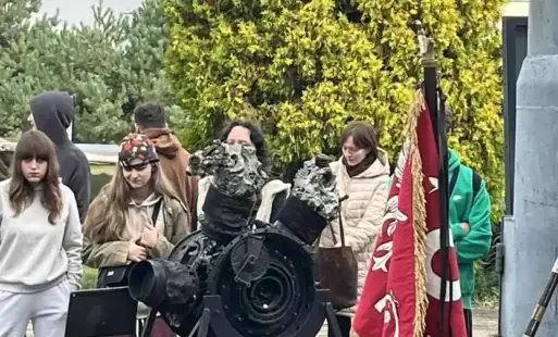 Grupa uczniów uczestnicząca w lekcji, na pierwszym planie mała armatka