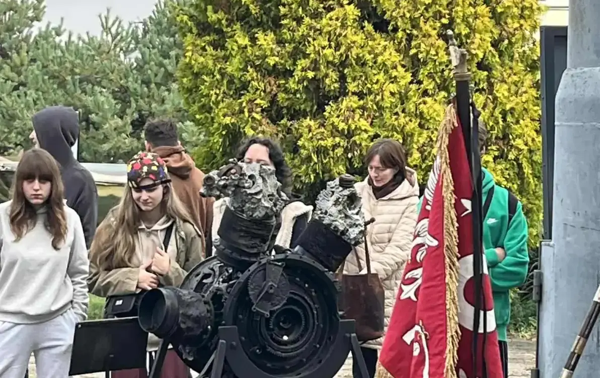 Grupa uczniów uczestnicząca w lekcji, na pierwszym planie mała armatka