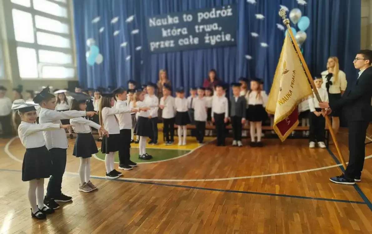 sala gimnastyczna, pierwszoklasiści przyrzekający na sztandar szkoły
