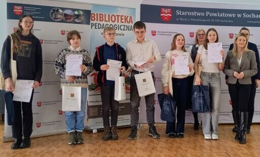 Laureaci z dyplomami w otoczeniu opiekunów