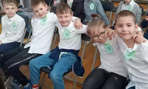 grupa uczniów siedząca na krzesłach